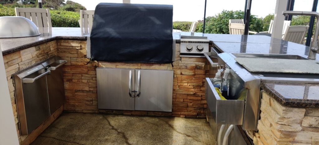 Full outdoor kitchen with a Lynx BBQ, burners, fridge and sink